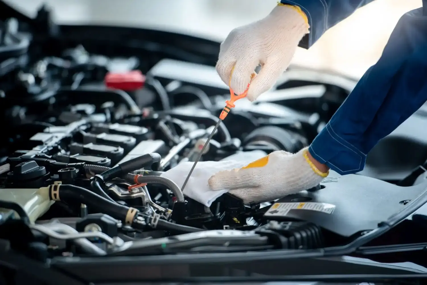 Asiatischer Automechaniker prüft Motor in einer Autowerkstatt.