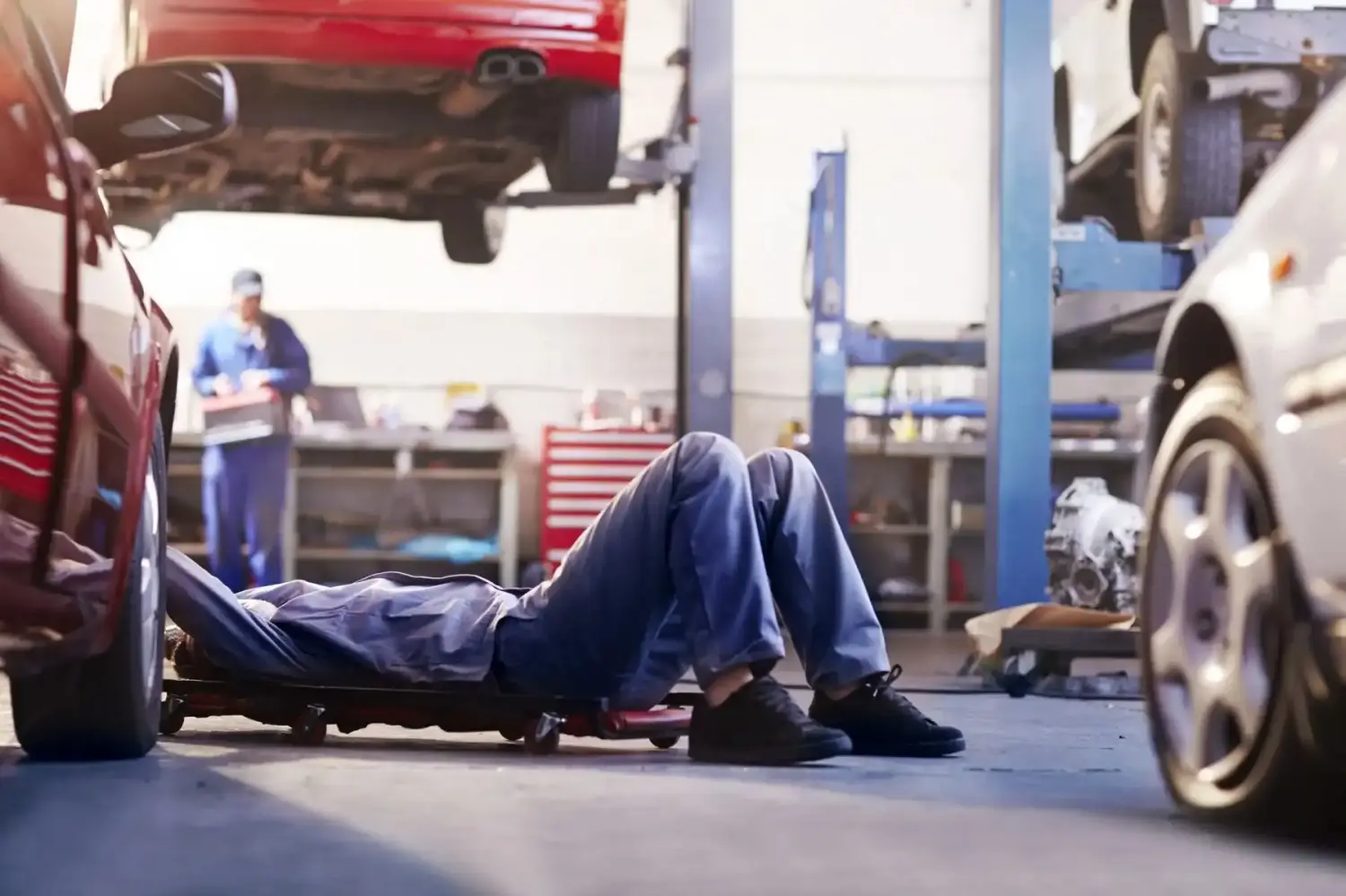 Mechaniker unter dem Auto in der Autowerkstatt.