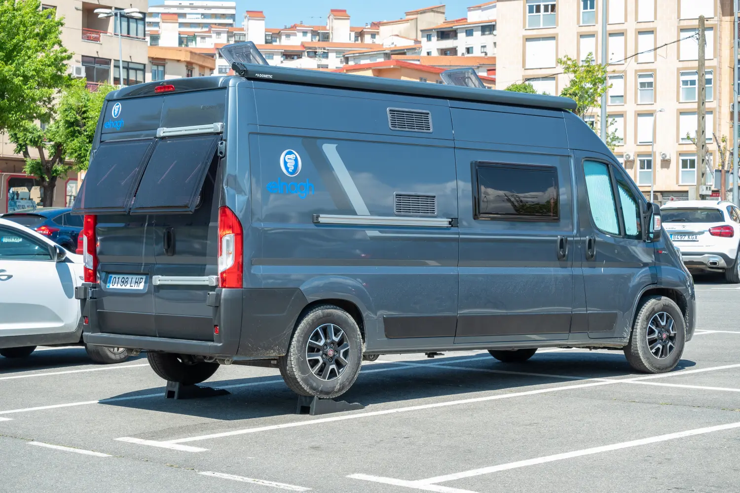 Frau wartet Wohnmobil mit Laterne und Werkzeug, während ihr Mann wartet.